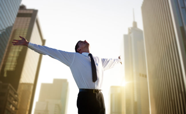 Happy young businessman and big city
